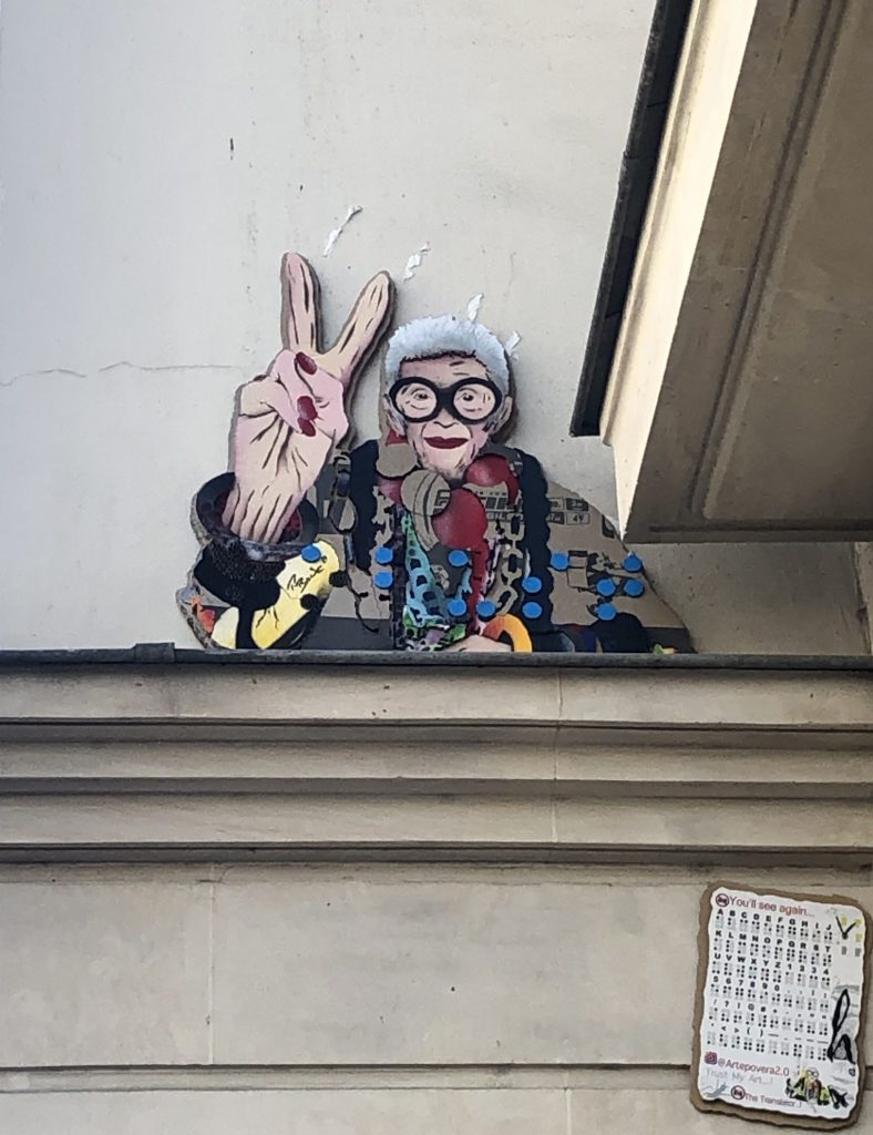 Le portrait d'Iris Apfel en street art sur un mur de bâtiment